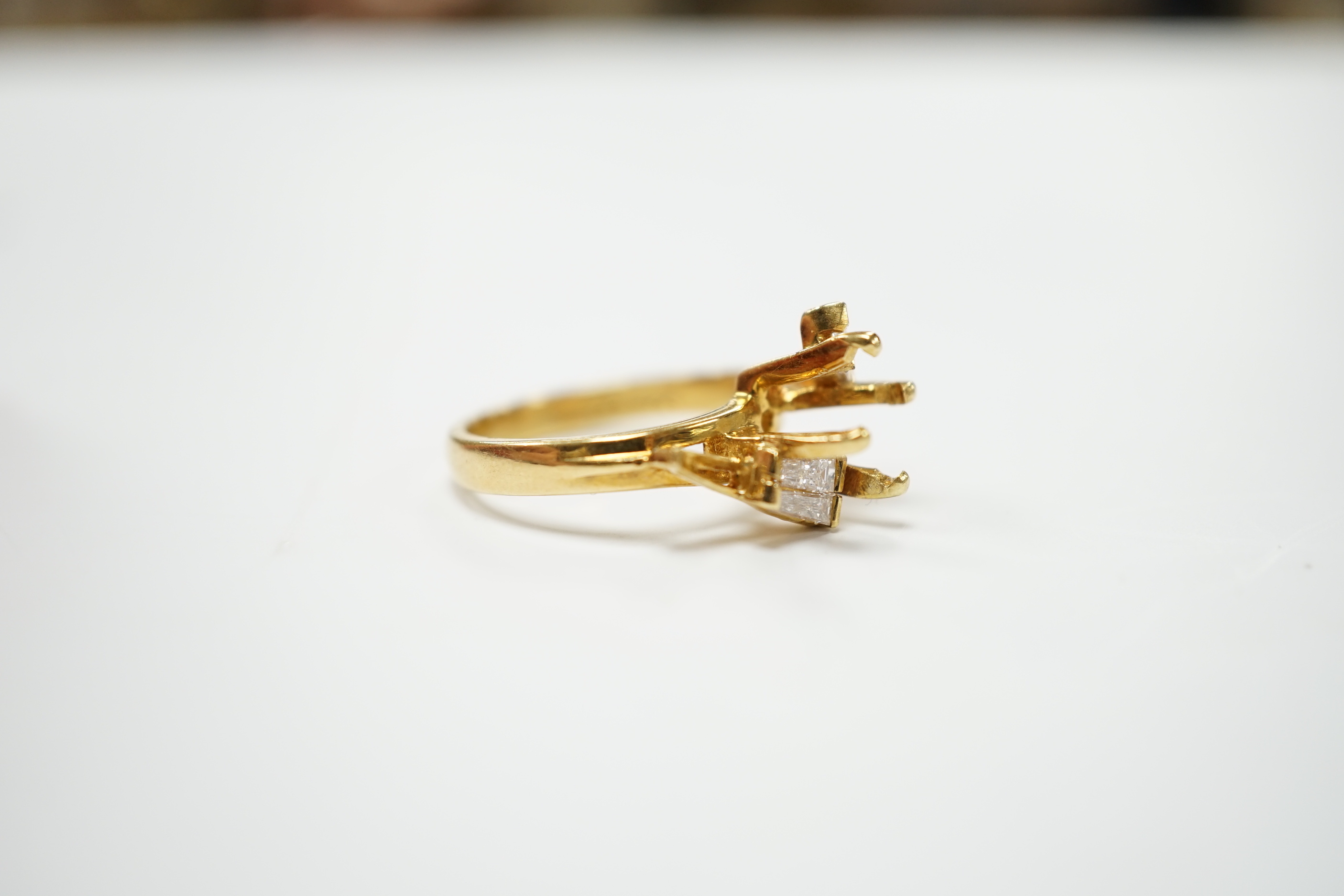 A modern 18ct gold and four stone trapeze cut diamond set crossover ring, size J, (central stone missing), size I/J, gross weight 4.6 grams.
